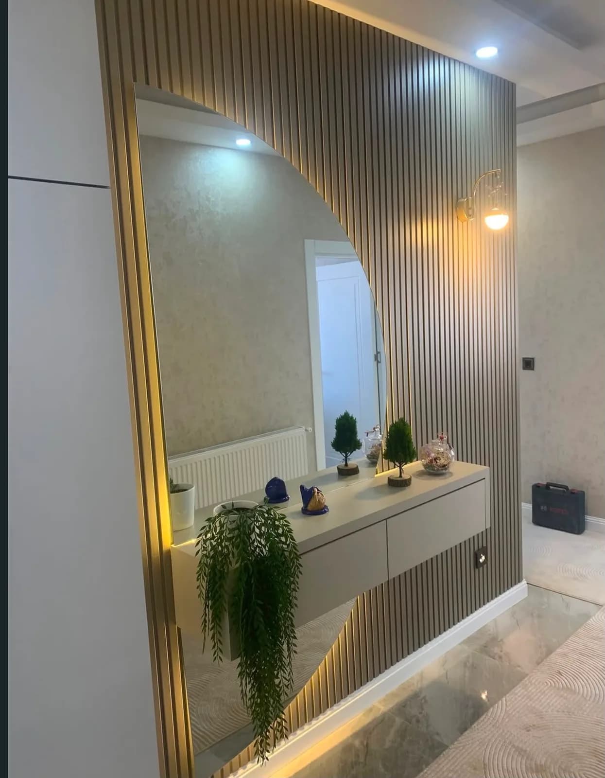 Mermer desenli zeminli koridorda ahşap çıta panel, LED ayna ve dresuar
