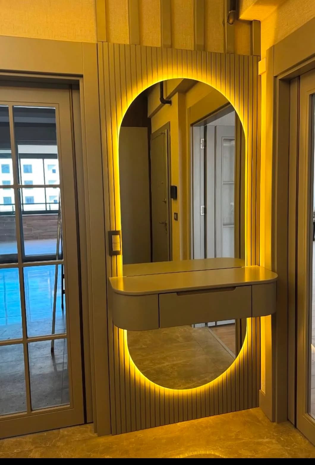 Çıtalı panelde oval LED ayna, sıcak ışıklı giriş holü